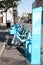 A row of blue rental bicycles sits along a city street