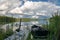 Row boat tied to a pier in a glassy lake in Sweden