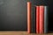 Row of Books with Blank Spines on Desk with Chalkboard Background