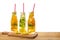 row of bottles lemonade with lemon, orange, lime, twig mint, cucumber, ginger and straws on wooden background isolated, concept o