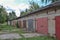 A row of brick garages with rusty metal gates. Russia