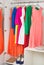 Row of bright colorful dress hanging on coat hanger, shoes and h