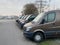 Row of brown transportation delivery vans being parked in front of warehouse