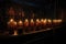 row of candles flickering in a dimly lit space