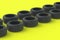 Row of car rubber tyres on yellow background