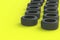 Row of car rubber tyres on yellow background