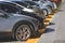 Row of cars parked neatly in parking lot area on the street