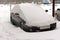Row of cars parked in the snow parking in the courtyard
