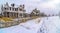 Row of charming houses with snowy yards inside the wooden fences in winter