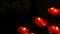 Row of christian prayer red round votive candles burn in the dark. Prayer lighting Sacrificial Candles close up. Burning