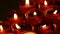 Row of christian prayer red round votive candles burn in the dark. Prayer lighting Sacrificial Candles close up. Burning