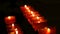 Row of christian prayer red round votive candles burn in the dark. Prayer lighting Sacrificial Candles close up. Burning