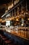 a row of clean, polished wine glasses hanging above a bar