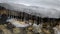 Row of clean transparent icicles hanging in cold forest creek water flow