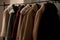 a row of coats hanging on a rail next to a window with a coat rack in front of it and several coats hanging on a rail