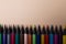 Row of color blackwood pencils at the bottom of the image on beige background with copy space.