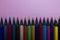 Row of color blackwood pencils at the bottom of the image on pink background with copy space.