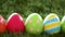Row of colored easter eggs on artificial grass