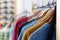 Row of colorful Apparel on Hangers of Retail Shop