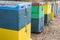 Row of Colorful Bee Hives With Trees in the Background. Bee Hives Next to a Pine Forest in Summer. Honey Beehives in the Meadow.