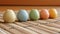 A row of colorful ceramic eggs on a bamboo mat, AI