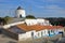 A row of colorful houses along a steep cobbled street inside Odeceixe near Aljezur, with a whitewashed traditional windmill, Cos