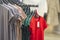 Row of colorful new modern unisex cotton t-shirts with price tags hanging on rack on blurred shop interior background. Fashion,