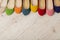 Row of colorful shoes ballerinas on a white wooden background.