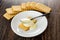 Row of cookies, spoon on cookie poured condensed milk in saucer on wooden table