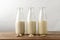 Row of Dairy Free Milk Alternatives with Ingredients on Wood Planked Table