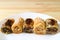 Row of delectable Baklava sweets on a white plate served on wooden table