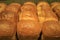 Row of delectable fresh baked bread loaves for background