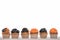 Row of delicious Halloween orange and black cupcakes isolated on white.