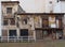 Row of derelict abandoned houses and commercial properties on a street with boarded up doors and windows and crumbling walls