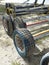 Row of Dinghy Sailing Wagon Wheels on Sand. Boat trailers. Beach carts background