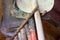 Row of dirty old stacked shovels on rail in outhouse with vintage gardening tools