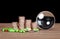 A row of dollar coins, a magnifying glass and capsule medicines scattered on the table in front of a dark background