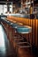a row of empty bar stools at a stylish restaurant counter