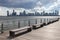 Row of Empty Benches on a Pier along the Hudson River in New York City with a view of the Jersey City Skyline