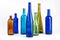 A row of empty glass wine bottles, different colors on a white background