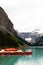 Row of empty red kayaks lined up on the edge of Lake Louise in Banff National Park