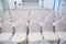 Row of empty White Chairs for Business Meeting event.