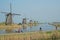 A row of famous windmills in Kinderdijk with cycling tourists