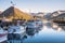 Row of fishing boats in a harbour with majestic mountains in background