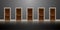 A row of five wooden doors on a gray wall. Dark corridor and reflection in the floor. For an article about choices or