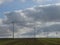 Row of four wind turbines surrounded by cottony clouds