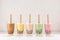 Row of fresh boba bubble tea glasses with straw on white background