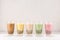 Row of fresh boba bubble tea glasses on white background