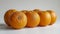 Row Of Fresh, Vibrant Oranges On A Clean White Surface With A Soft Shadow