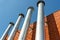 A row of galvanized chimneys on the facade of a red brick building
